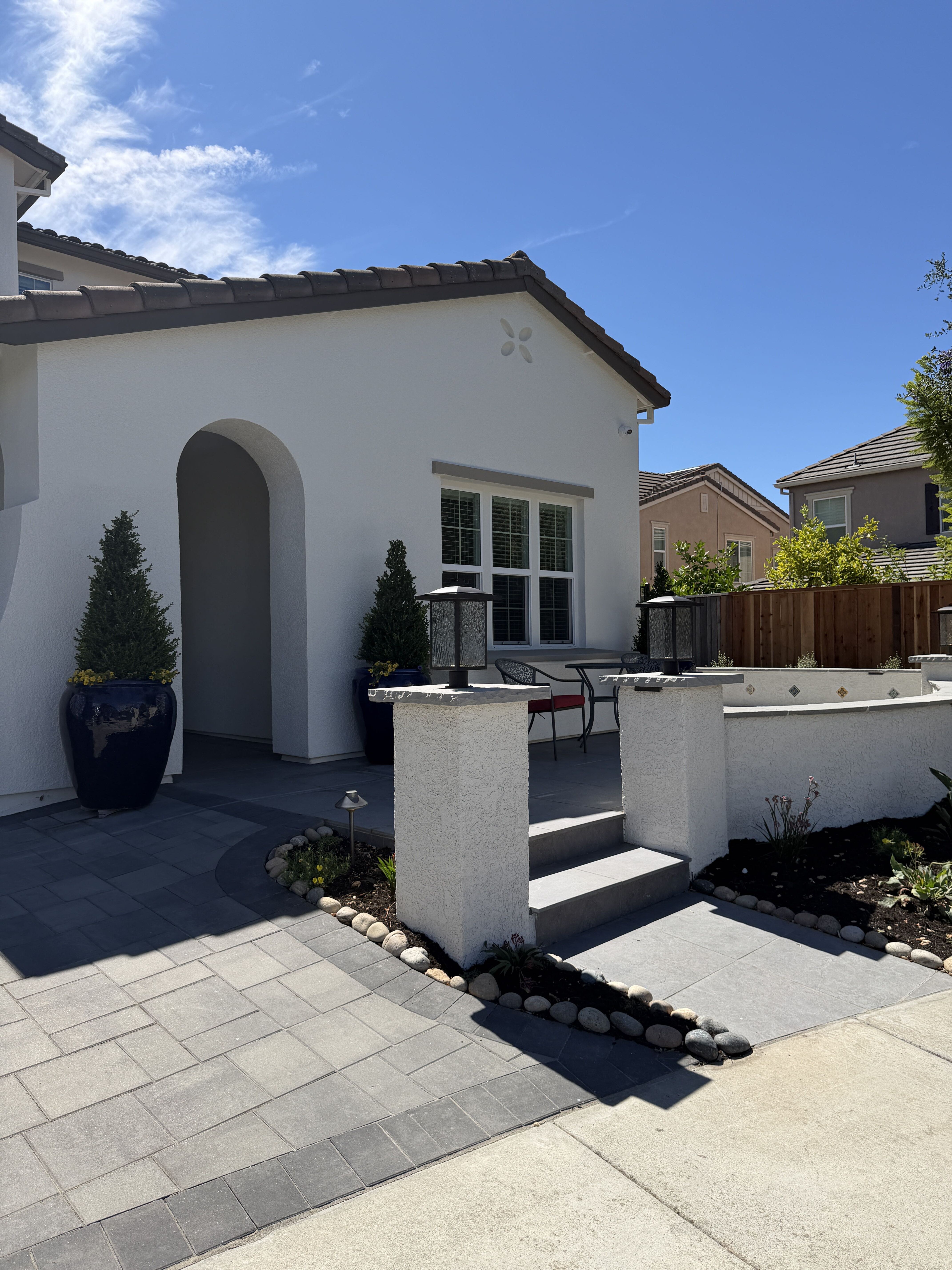 Finished Dublin front entry and planting beds Finished paved front entry with stucco garden walls, lanterns, steps and planted borders in Dublin.